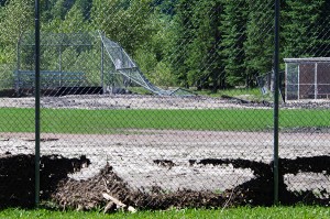 Part of a baseball diamond backstop in Fernie's James White Park lies mangled after the Elk River galloped over its banks June 20. Note the debris matted along the bottom of the fence to get an idea as to the height of the flood water level. Ian Cobb/e-KNOW