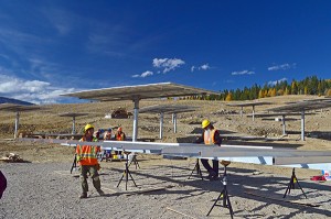 Crews work to assemble tabletop supports on which photovoltaic modules are mounted. Photo by John Allen