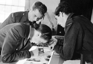 Here is a photo of a Women’s Auxiliary Air Force officer examining the photos for bomb damage.