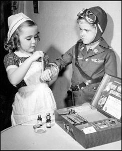 Toys of Yesteryear Toyland joins the war. Patsy Ann McHugh, as a nurse, bandages the hand of a "wounded aviator", Bobby O'Connor, using a nurse's kit during a demonstration by toy manufacturers in New York. 1942