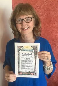 Photo of Elinor holding copy of poem.